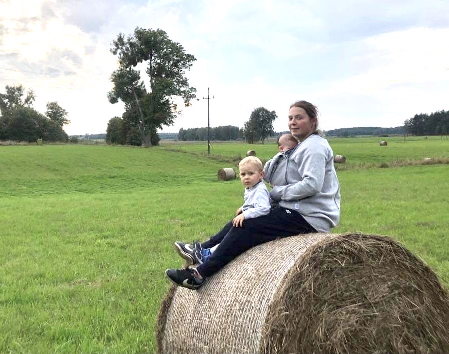 Aleksandra Młodkowska nosząca dziecko na wsi